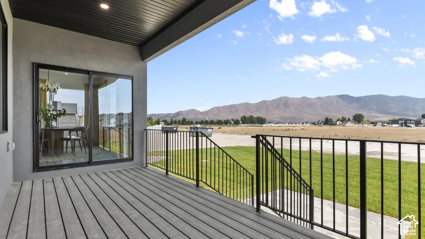 Covered deck with textured siding, composite decking, and black metal railings