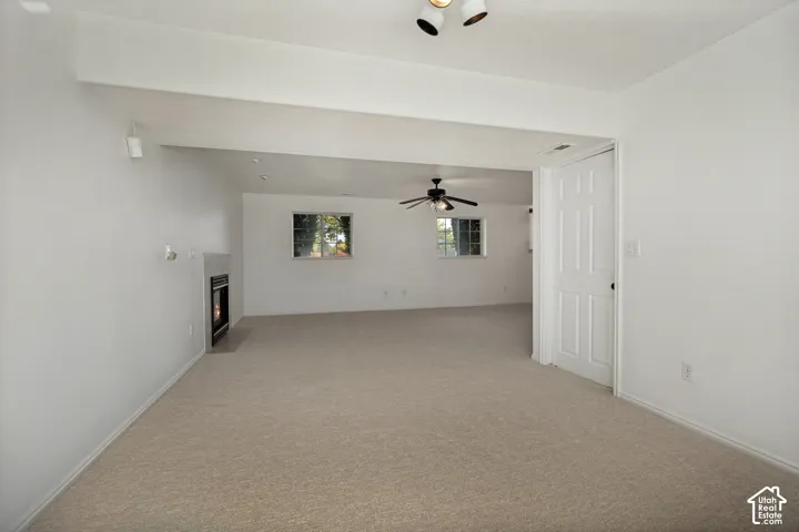 Neutral-toned carpet flooring, recessed lighting, white walls, and a built-in fireplace