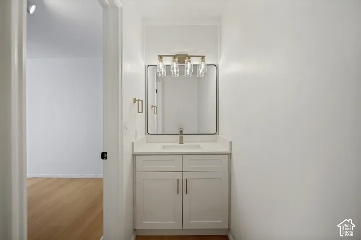 Vanity with a rectangular undermount sink, countertop, and a wall-mounted faucet