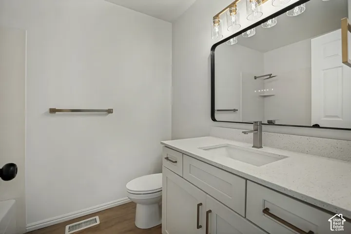 White shaker-style vanity with a light-colored countertop, undermount sink, and brushed nickel faucet
