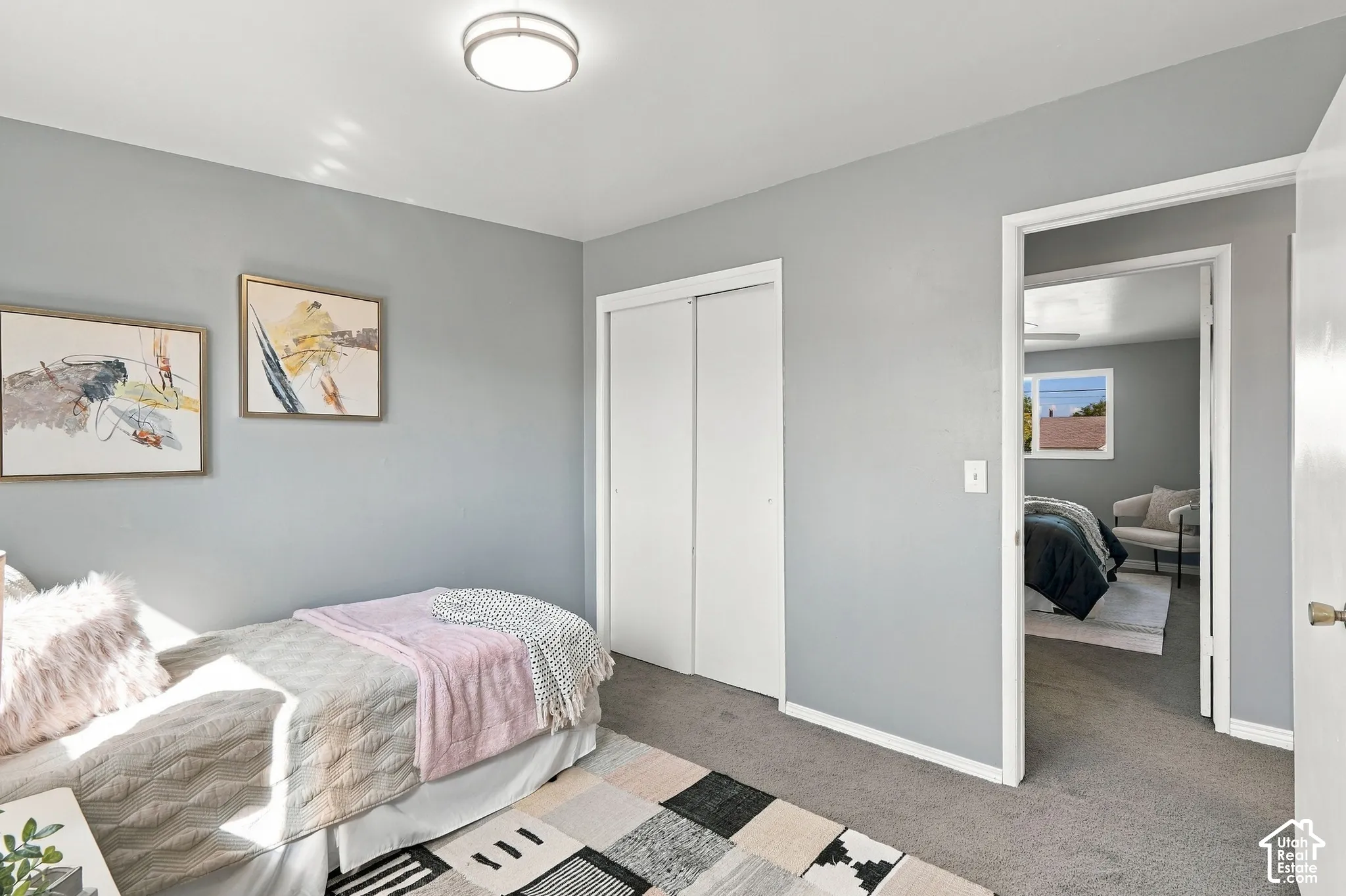 Gray wall finish, ceiling-mounted light fixture, sliding closet doors, and gray carpet flooring