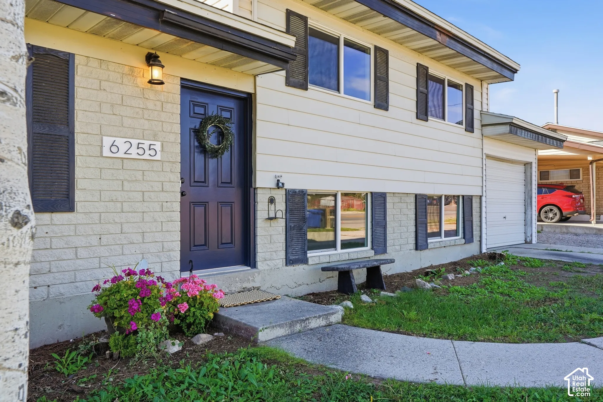 Split-level residence featuring a blue entry door, light brick accents, and a white garage door