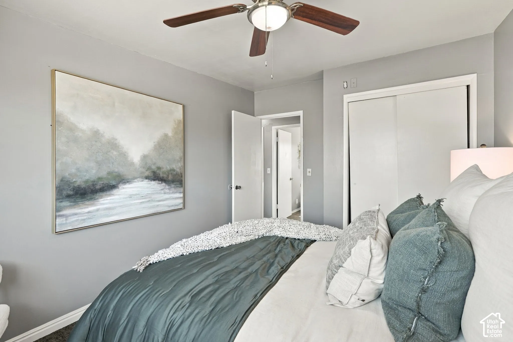 Ceiling fan with integrated lighting, wall-to-wall carpeting, and sliding closet doors