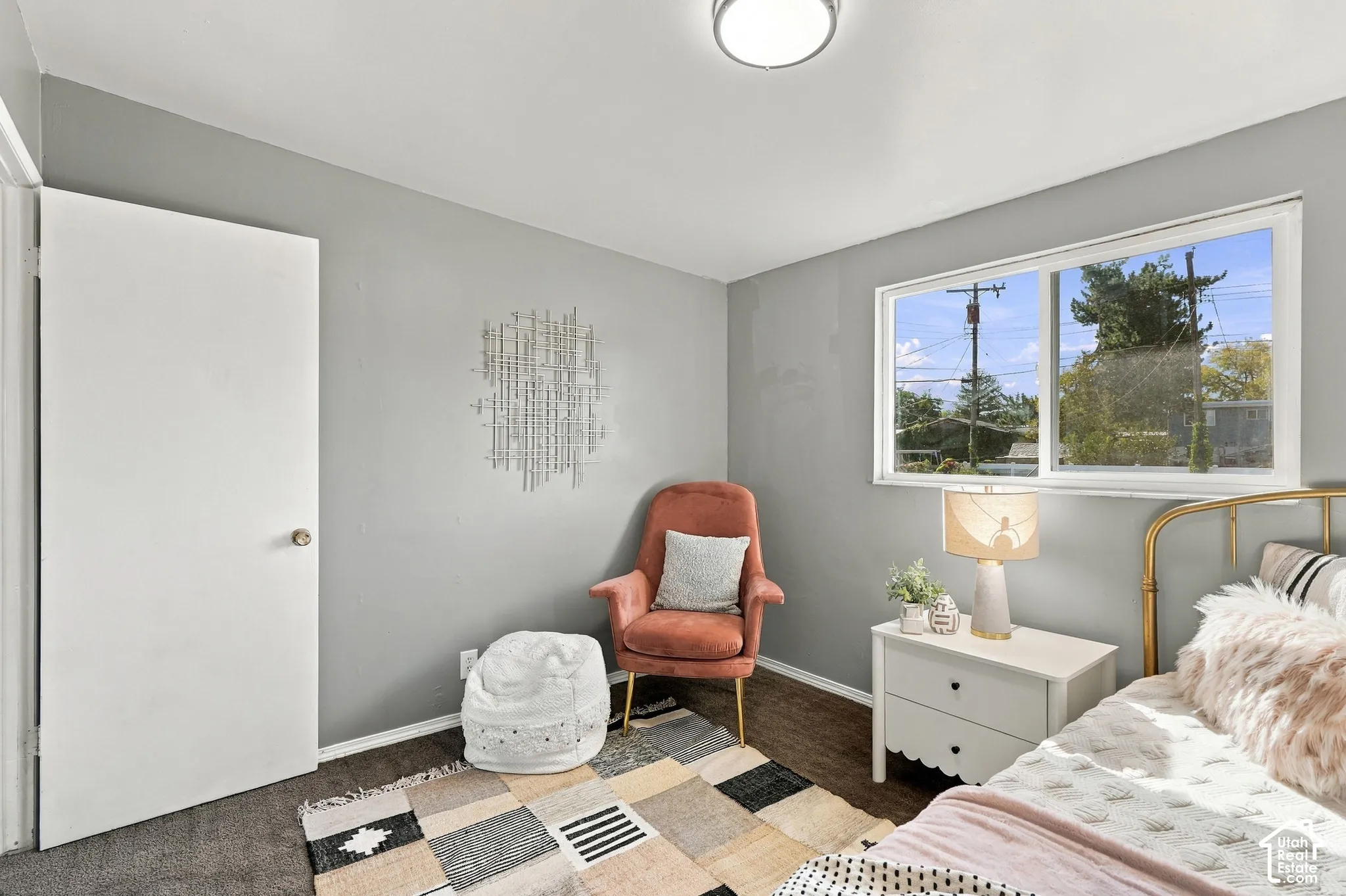 Room featuring a flush-mount ceiling light, a white interior door, a large window, and wood-finish flooring