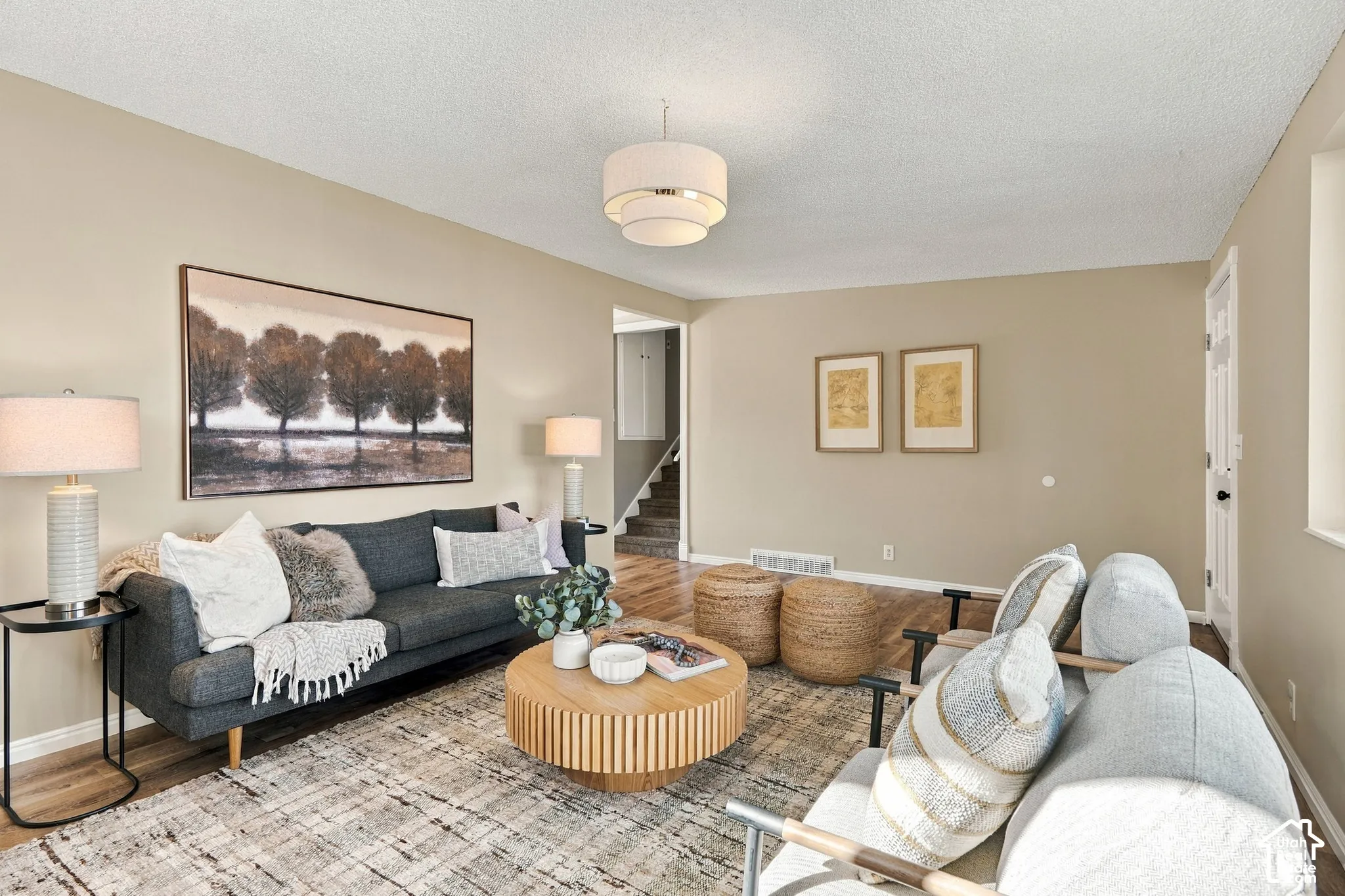 Recessed lighting, wood-finish flooring, neutral wall tones, and a multi-tiered ceiling fixture