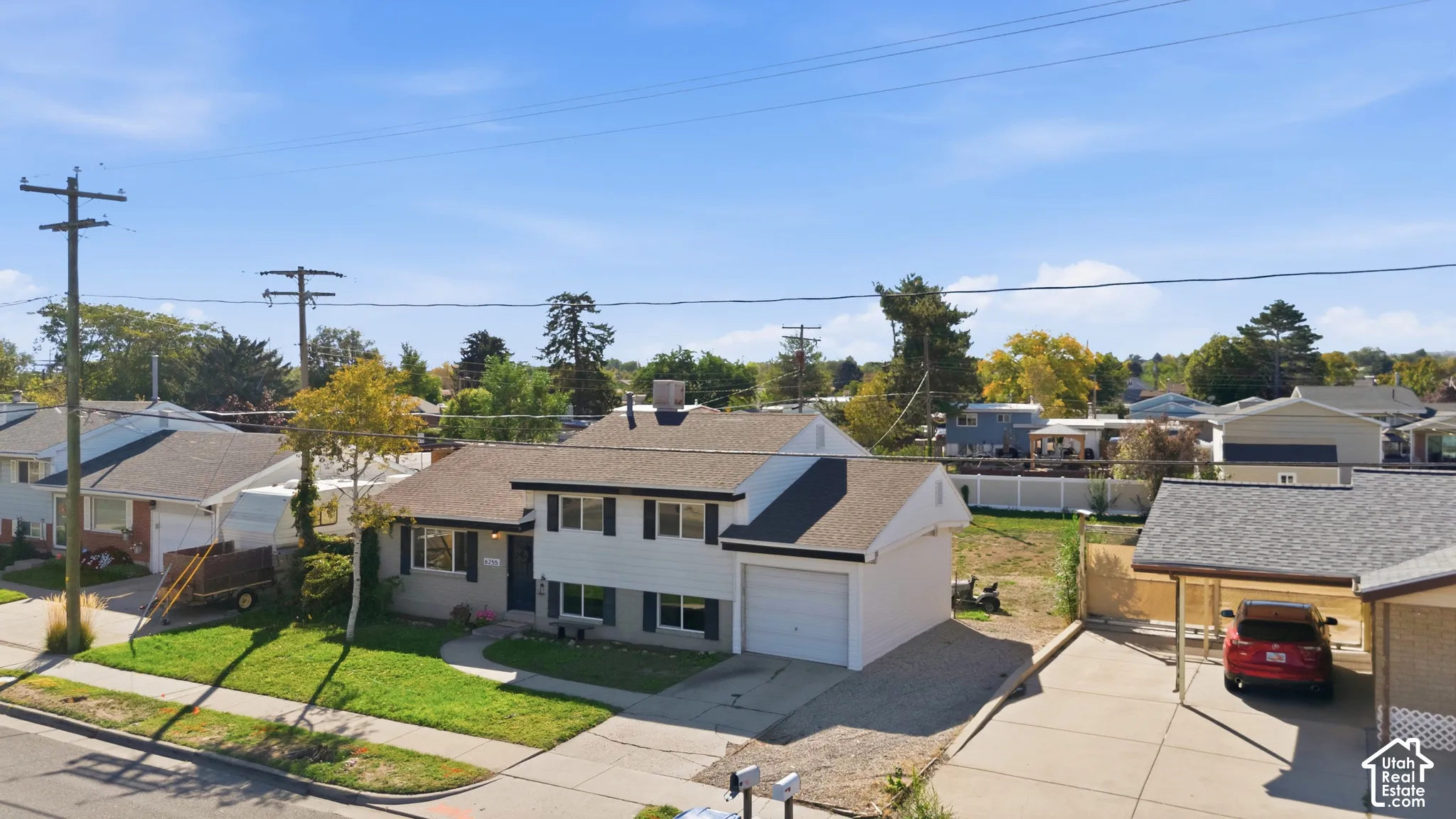 Split-level residence featuring a two-car garage, carport, and asphalt shingle roof