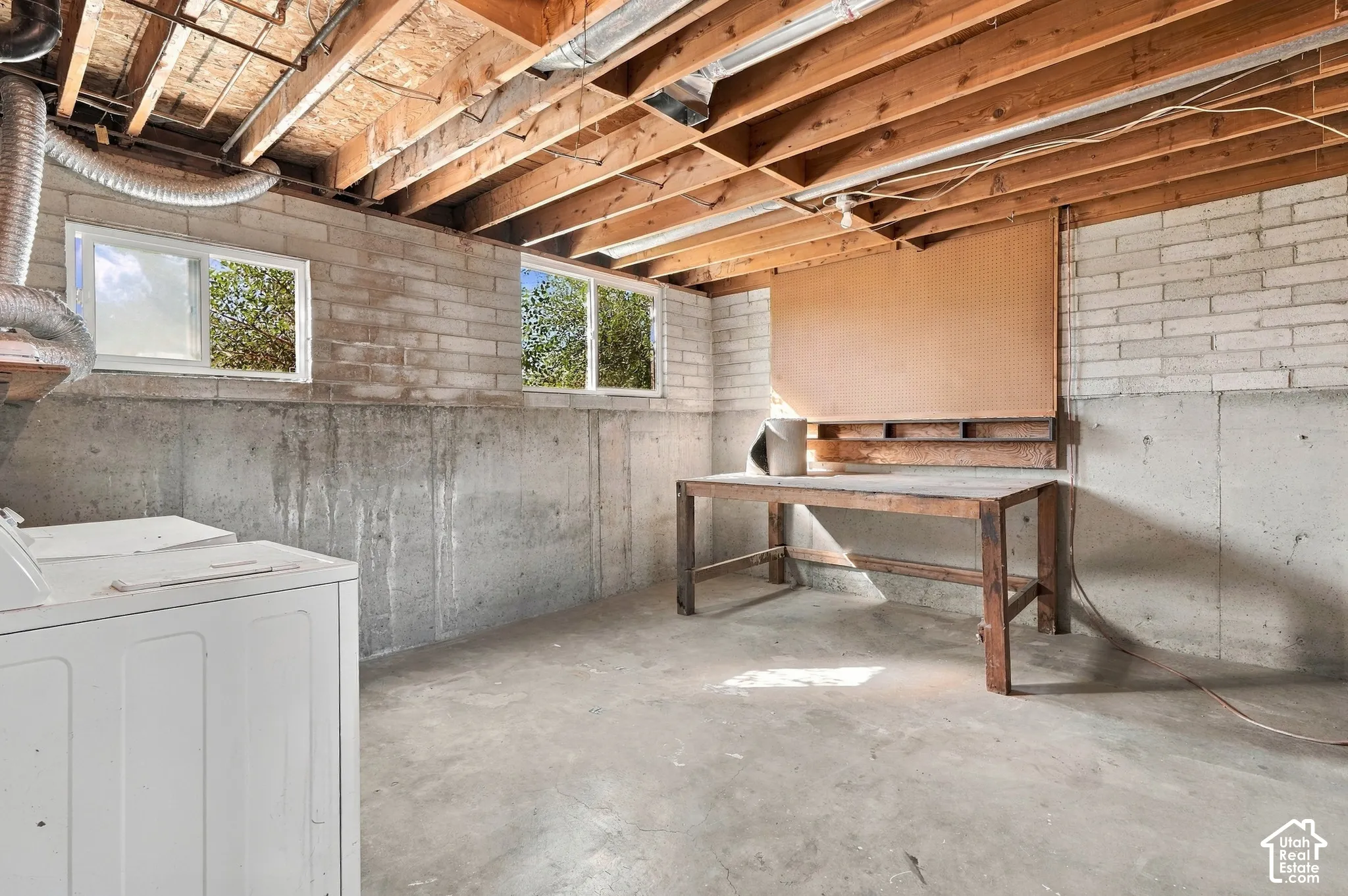 Finished concrete flooring with exposed wood joist ceiling and brick wall accents