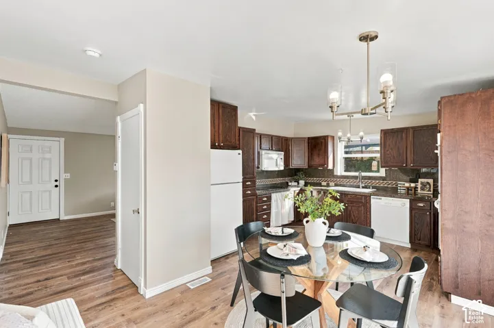 Kitchen featuring dark wood cabinetry, a mosaic tile backsplash, and stainless steel appliances