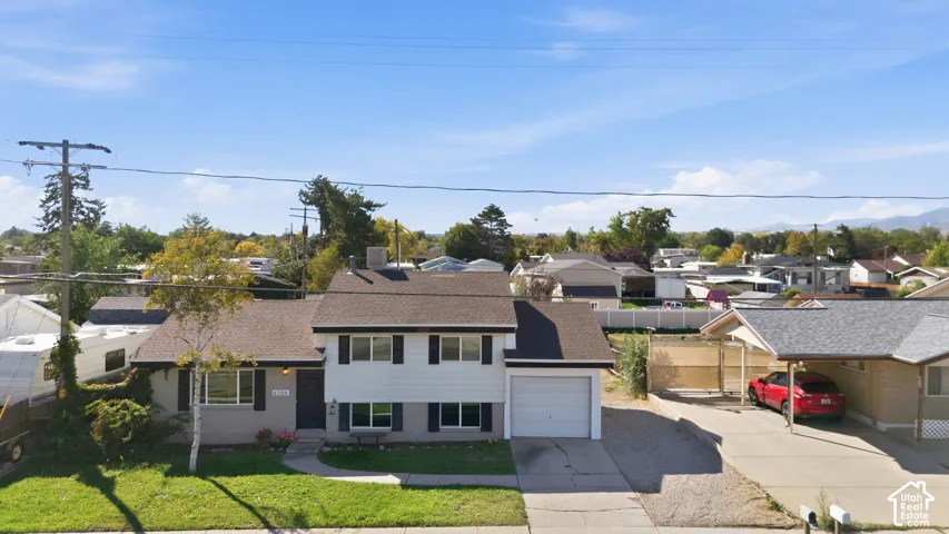 Two-story residence featuring a front lawn and paved driveway