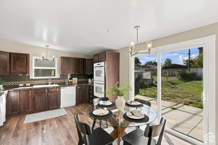 Wood-finish flooring throughout, dark wood cabinetry, and a dark tile backsplash