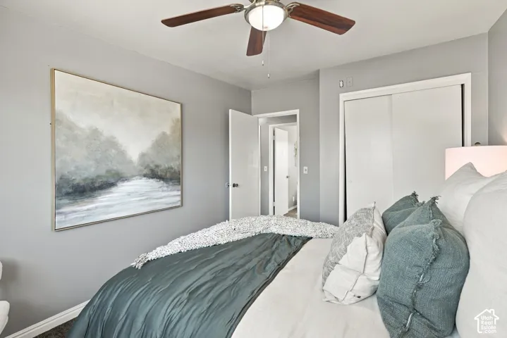 Ceiling fan with integrated lighting, wall-to-wall carpeting, and sliding closet doors