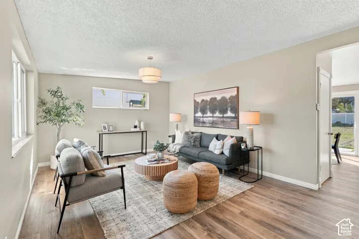 Recessed lighting, wood-finish flooring, light-colored walls, and a contemporary chandelier