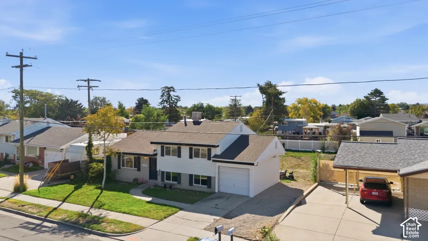 Split-level residence featuring a two-car garage, carport, and asphalt shingle roof