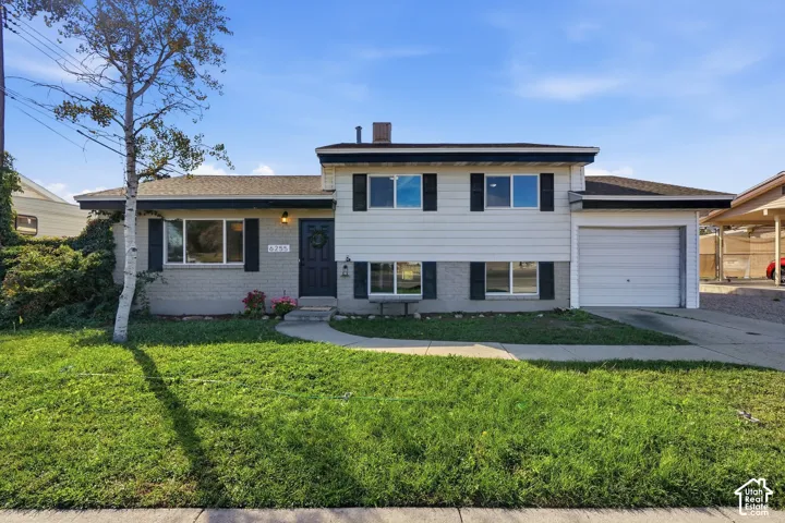 Two-story residence with a split-level design, attached garage, and an additional carport