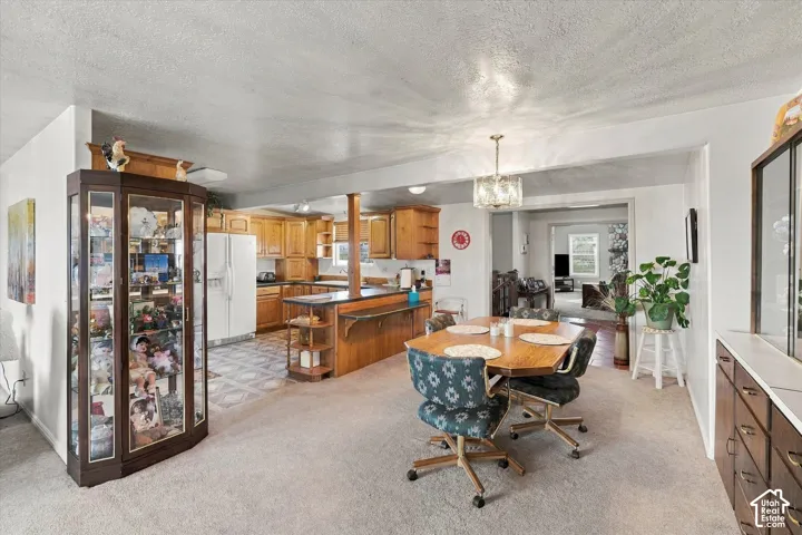 Kitchen with wood-finish cabinetry, white appliances, and patterned floor tile