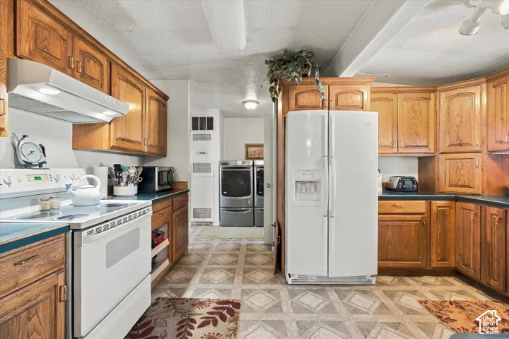 Spacious kitchen featuring wood cabinetry throughout, white appliances including a side-by-side refrigerator and electric range, laminate countertops, ceramic tile flooring, and ample storage