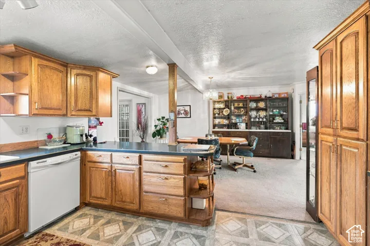 Kitchen featuring wood cabinetry, white appliances, and a peninsula with countertop seating