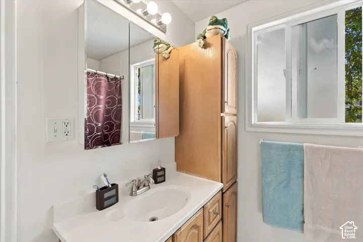 Bathroom vanity with an integrated sink, polished chrome faucet, and wood-finish cabinetry