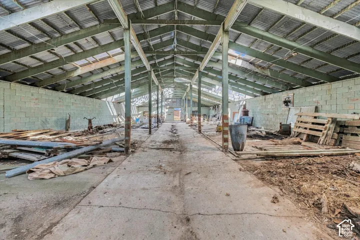 Concrete floor, exposed structural beams, corrugated metal roof, block walls, open-span interior
