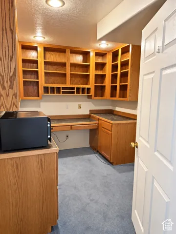 Wood-finish cabinetry with built-in shelving, integrated desk space, and dark countertops