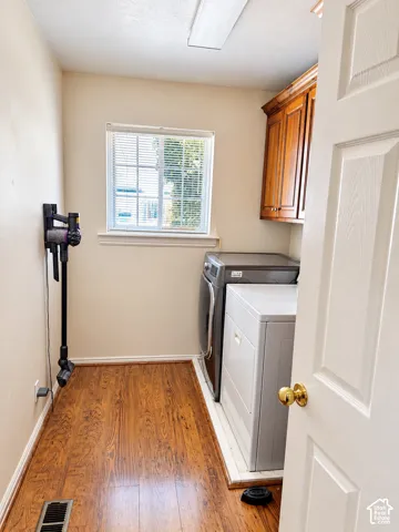 Wood-finish flooring, natural light through a window, and built-in wood cabinetry