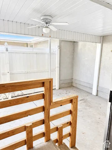 Covered patio with a ceiling fan, concrete flooring, and privacy fencing