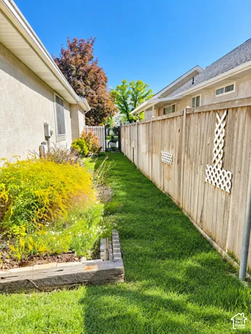 Manicured lawn area with a wood retaining wall and mature shrubs