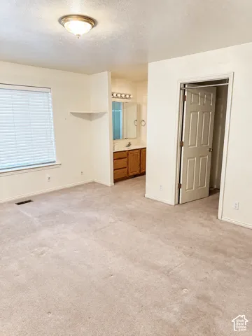 Recessed vanity with wood-finish cabinetry and overhead lighting