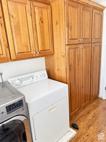 Wood-finish flooring with extensive wood cabinetry featuring upper and lower storage