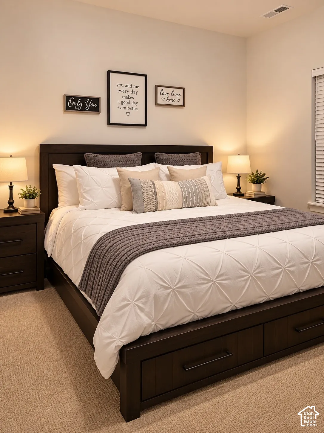 Recessed lighting, wood-finish bed frame, integrated storage drawers, wood-finish nightstands, and carpet flooring