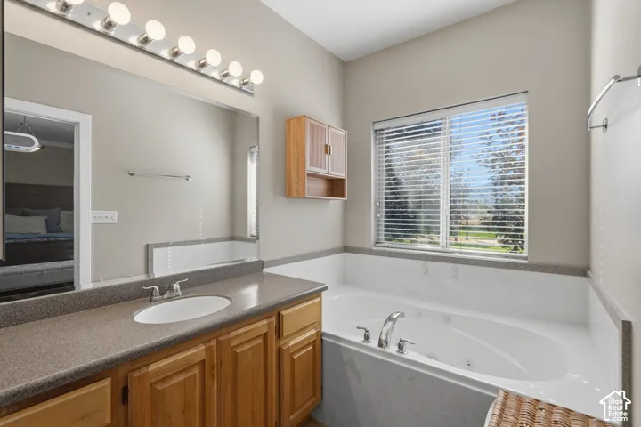 Built-in vanity with a single basin, wood-finish cabinetry, and an expansive mirror