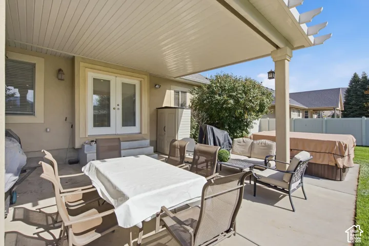 Expansive patio featuring a solid roof covering, support columns, and French doors