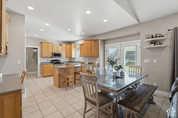 Kitchen with light wood-finish cabinetry, stainless steel appliances, and a central island