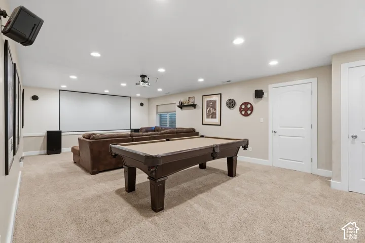 Spacious recreation area featuring recessed lighting, a built-in projection screen, and two panel doors