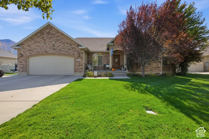 Brick exterior, integrated two-car garage, concrete driveway, front porch, mature landscaping