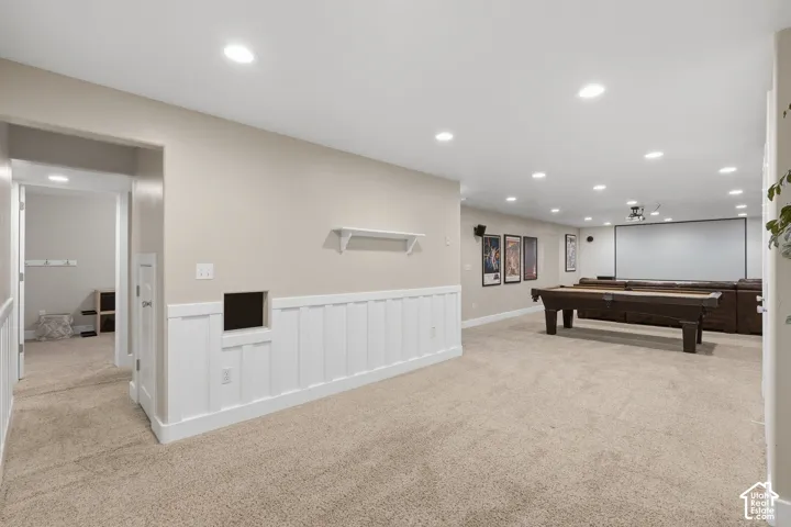 Open recreation room with recessed lighting, integrated projector, and large screen
