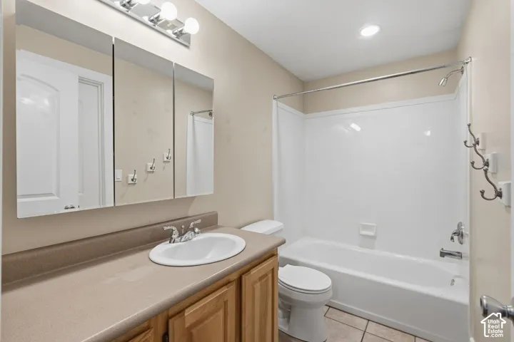 Built-in vanity with wood-finish cabinetry, integrated sink, and laminate countertop