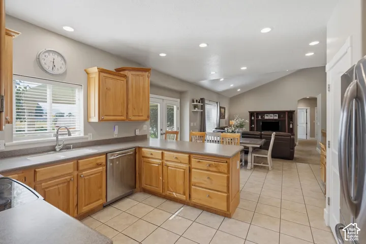 Kitchen featuring wood cabinetry, stainless steel appliances, and a central island with countertop seating