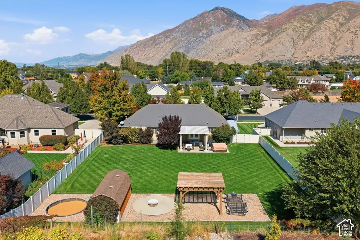 Expansive backyard featuring a manicured lawn, established privacy fencing, and a dedicated patio area
