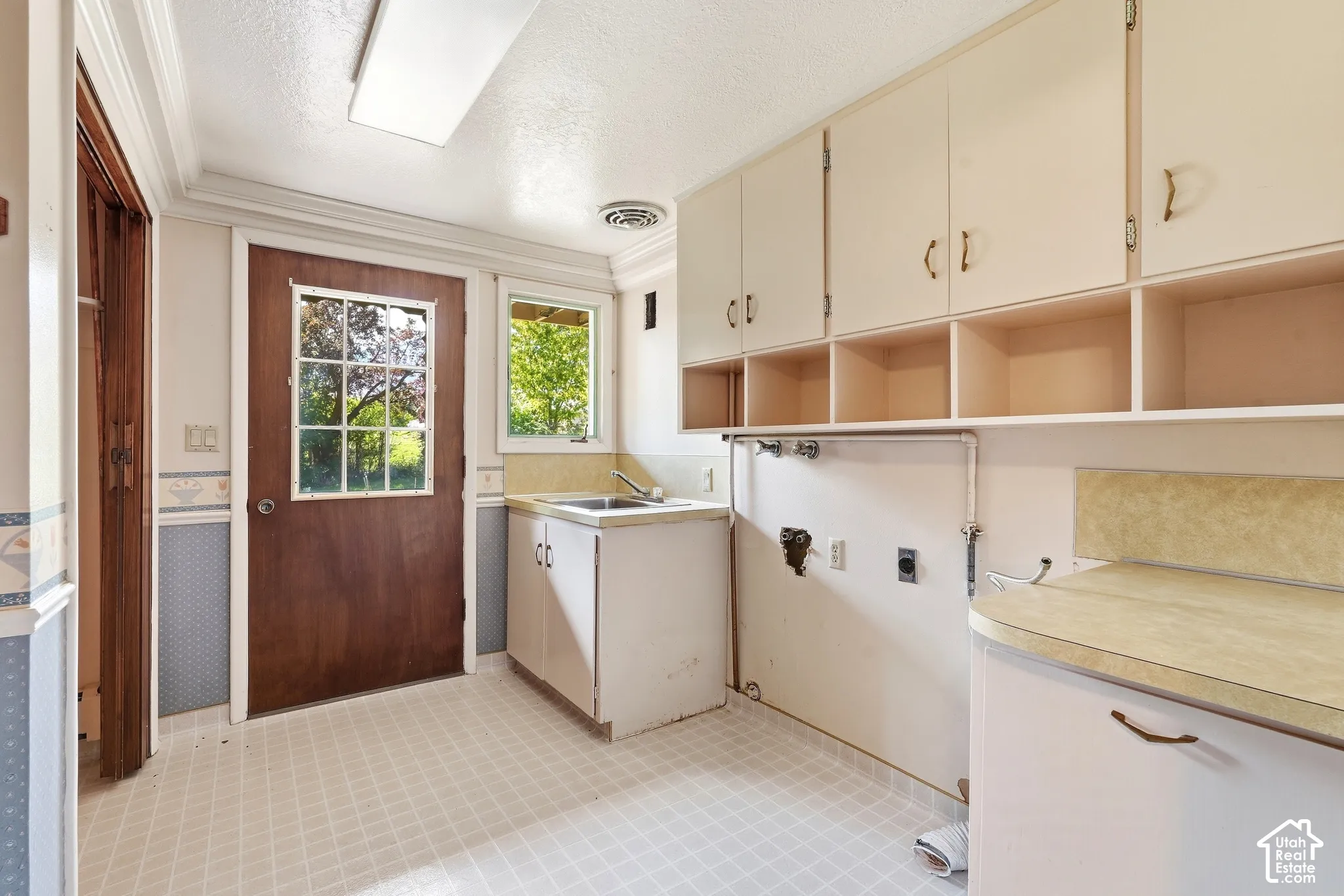 Built-in cabinetry with open shelving, an integrated sink, a solid surface countertop, and a window with natural light