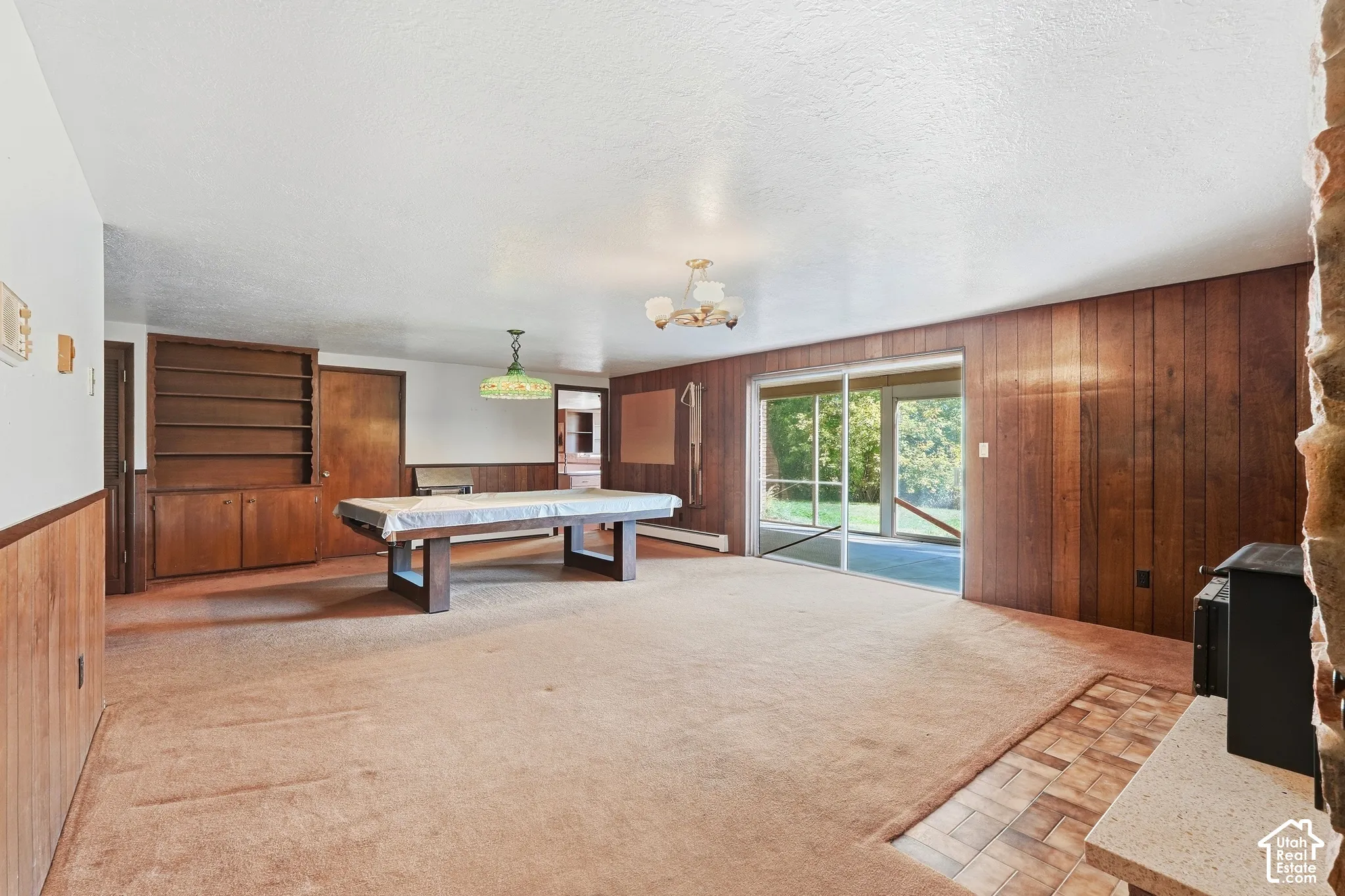Wood paneling accents, built-in shelving, and a sliding glass door