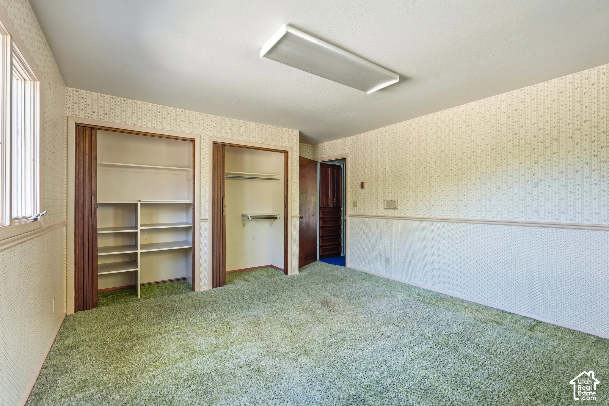 Room with dual closet spaces, built-in shelving, and recessed lighting