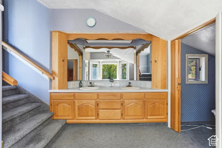 Double vanity with wood-finish cabinetry, integrated sinks, and individual mirrors