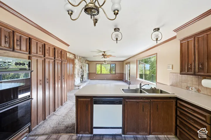 Kitchen featuring wood cabinetry, a double basin sink, and a built-in dishwasher
