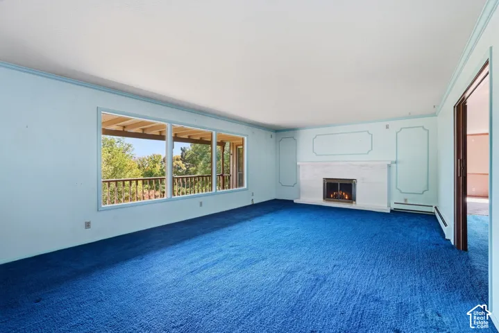 Integrated fireplace with a white mantel, expansive window offering exterior views, and a balcony with wood railing