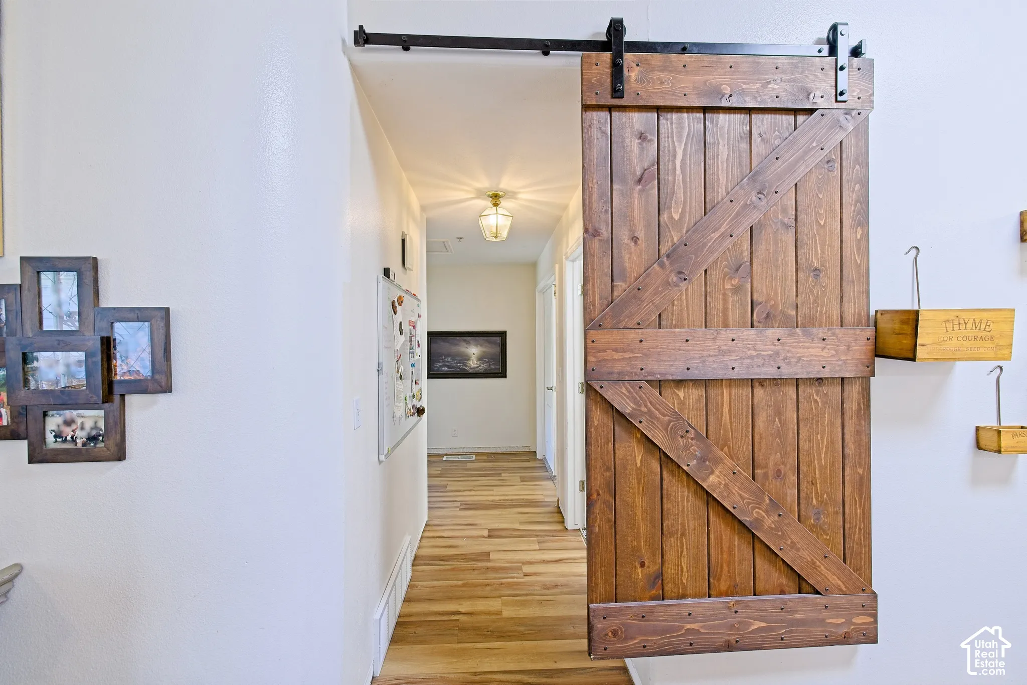 Wood-finish flooring throughout, with a built-in barn door featuring dark wood construction and black hardware