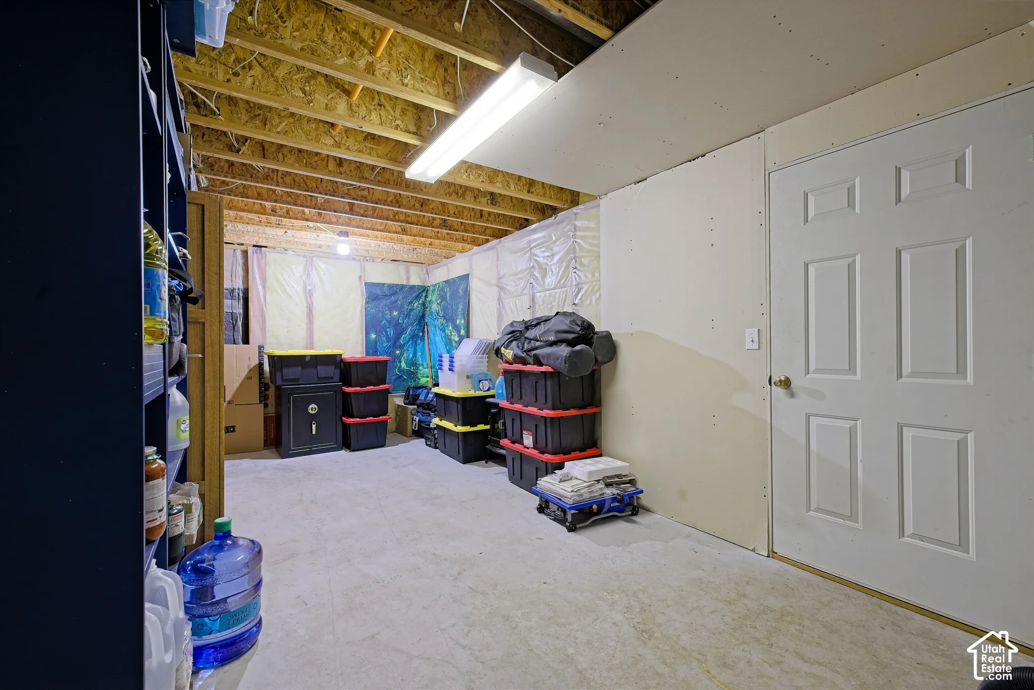 Unfinished basement area with exposed joists and concrete flooring