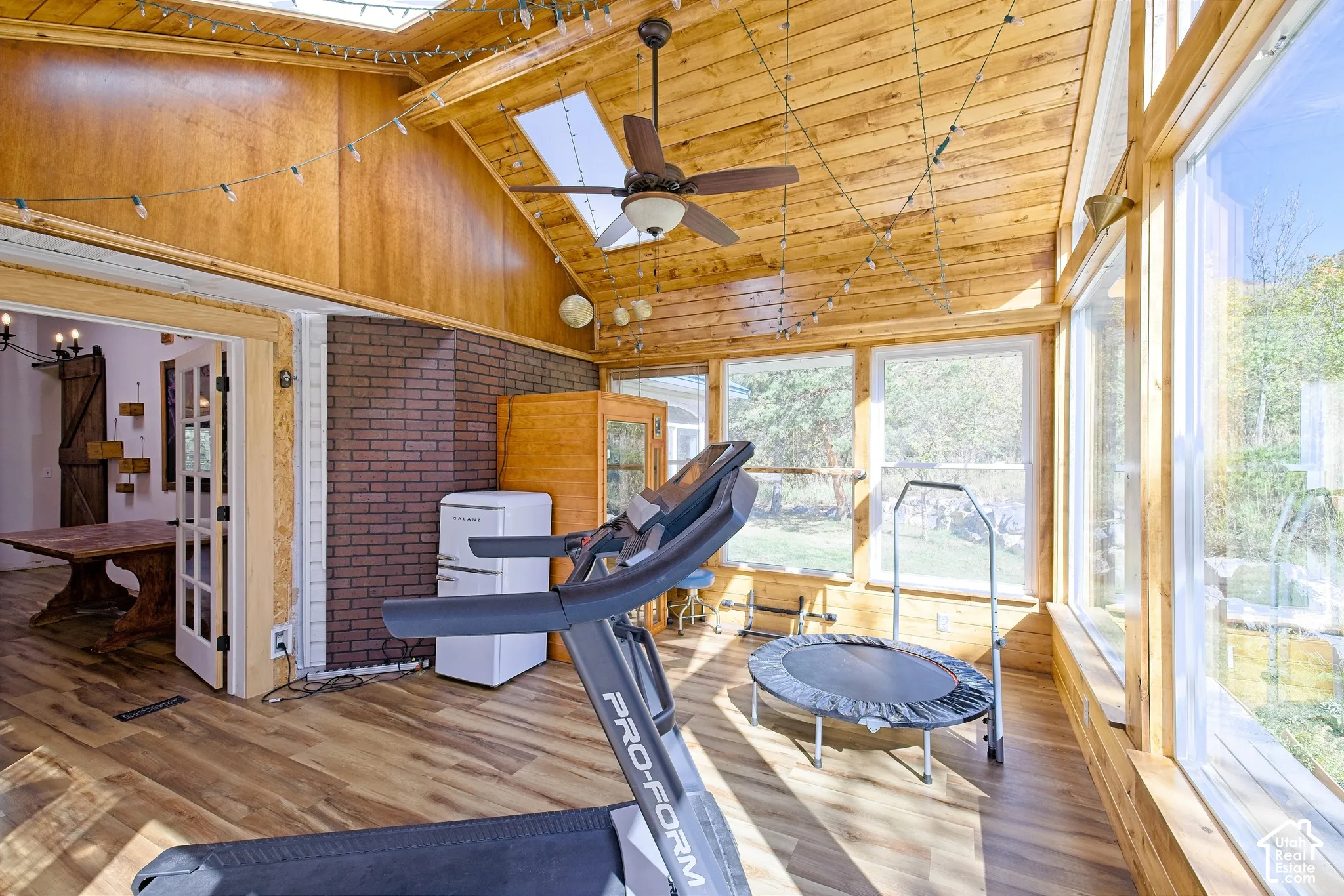 Expansive sunroom featuring wood-finish flooring, a wood plank ceiling, and large windows