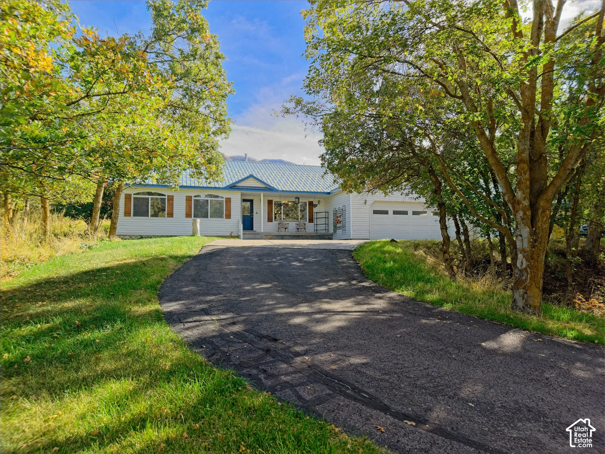 White siding exterior with a light blue metal roof