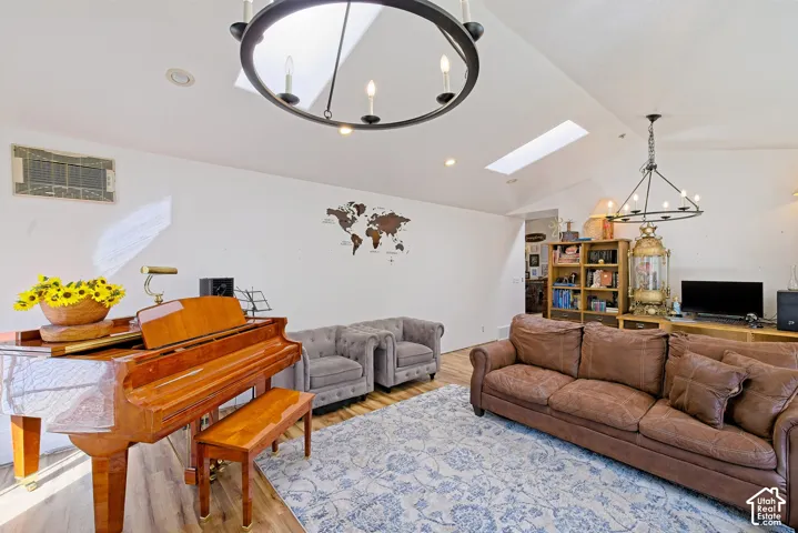 Vaulted ceilings with skylights, wood-finish flooring, and recessed lighting